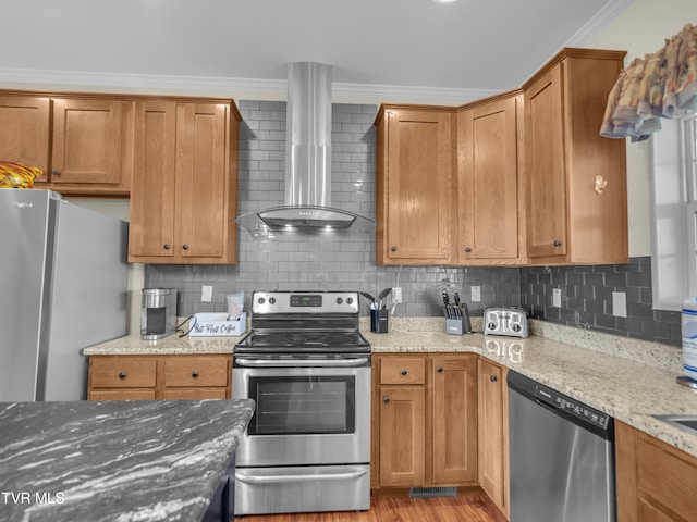 kitchen with appliances with stainless steel finishes, decorative backsplash, wall chimney exhaust hood, and ornamental molding