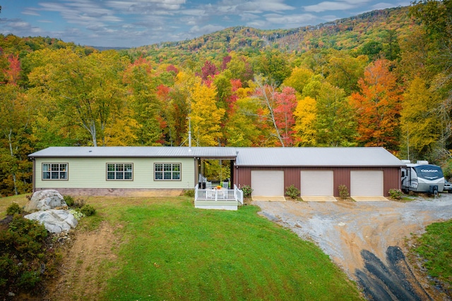 ranch-style house with an outdoor structure, a front lawn, and a garage