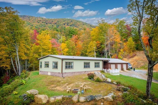 view of front of home with a front lawn and a mountain view