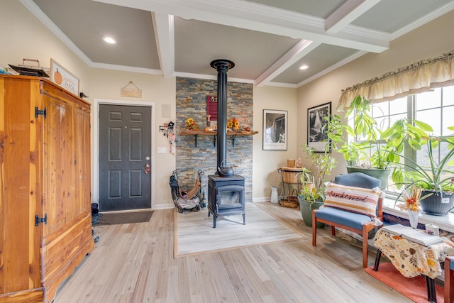 living area featuring light hardwood / wood-style flooring, ornamental molding, a wood stove, and beam ceiling