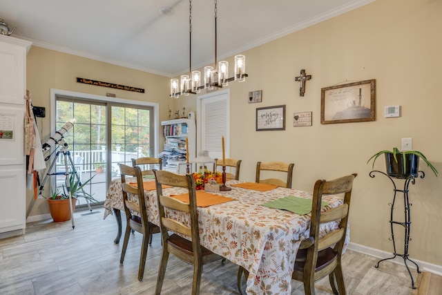 dining space with a notable chandelier, light hardwood / wood-style flooring, and ornamental molding