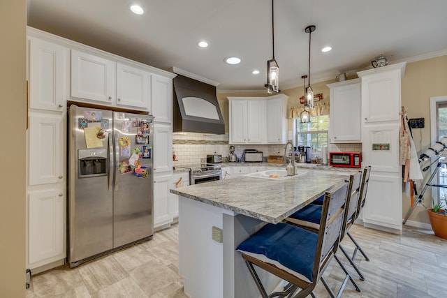 kitchen featuring an island with sink, appliances with stainless steel finishes, premium range hood, tasteful backsplash, and white cabinetry