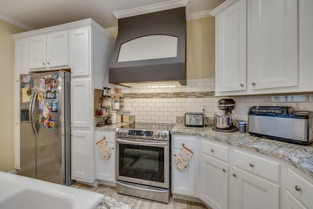 kitchen with white cabinets, appliances with stainless steel finishes, light hardwood / wood-style floors, and light stone countertops