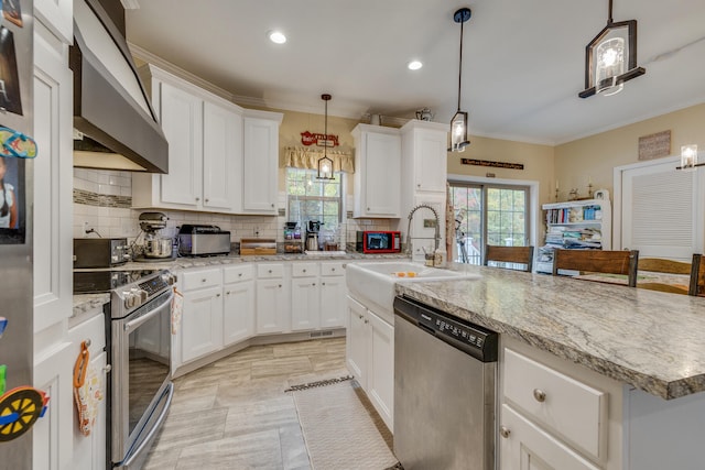 kitchen featuring pendant lighting, tasteful backsplash, wall chimney range hood, an island with sink, and stainless steel appliances