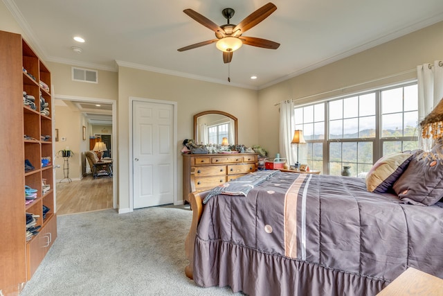 carpeted bedroom with ceiling fan and ornamental molding