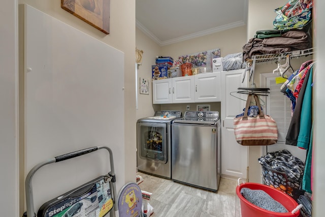 washroom with cabinets, washer and clothes dryer, and ornamental molding