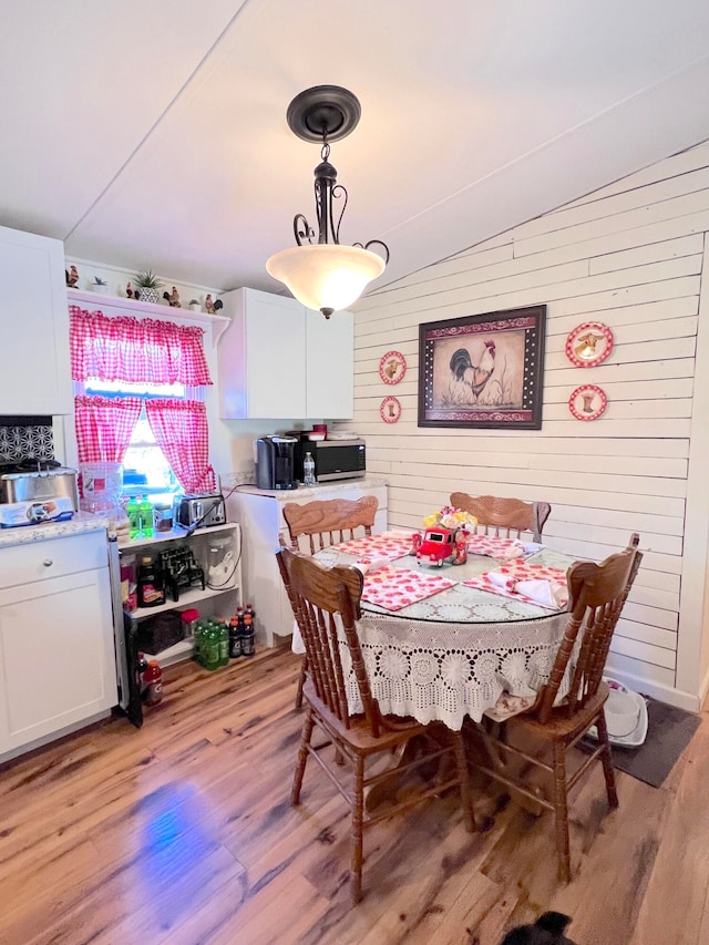 dining room featuring light hardwood / wood-style floors and lofted ceiling