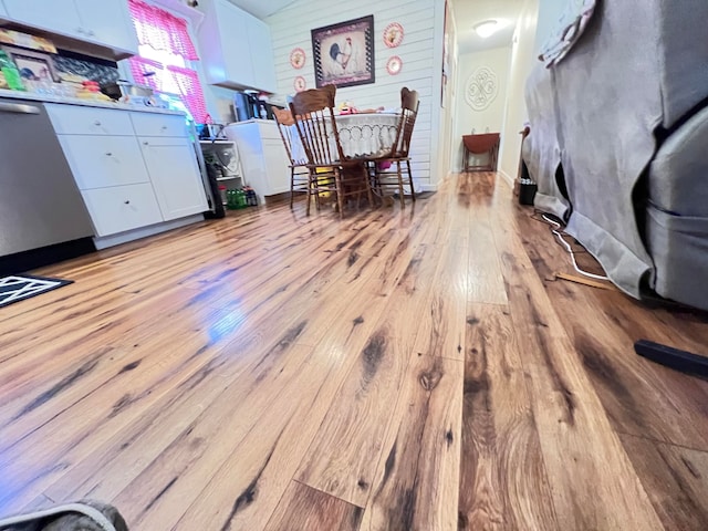 interior space with light hardwood / wood-style floors and wooden walls