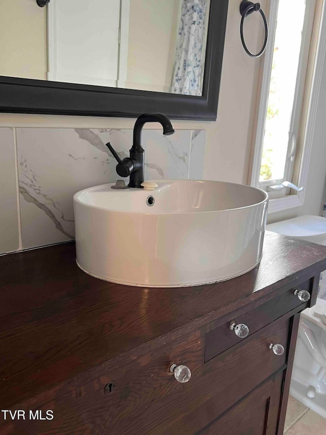 bathroom featuring decorative backsplash and vanity