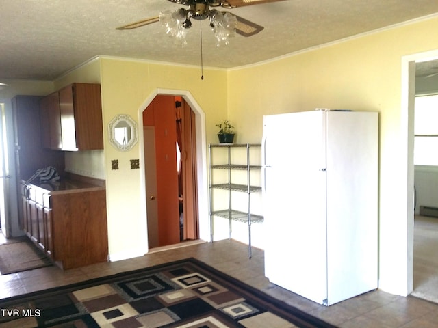 kitchen featuring plenty of natural light, crown molding, white fridge, and ceiling fan