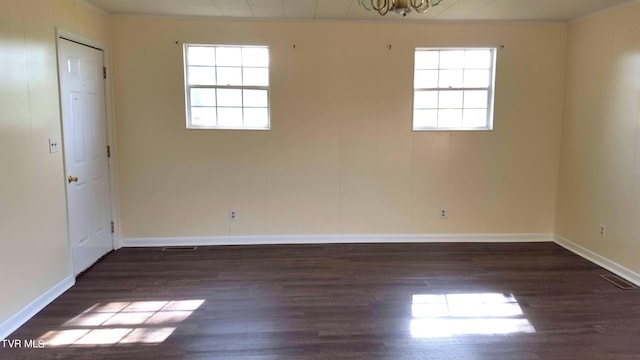 empty room featuring a healthy amount of sunlight and dark wood-type flooring