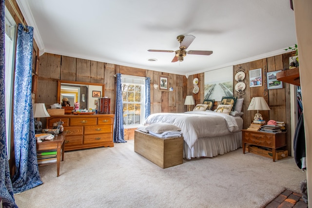 carpeted bedroom with crown molding, ceiling fan, and wood walls