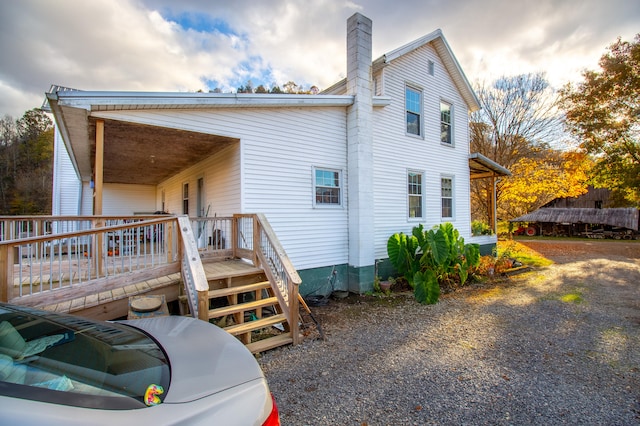 rear view of property featuring a wooden deck