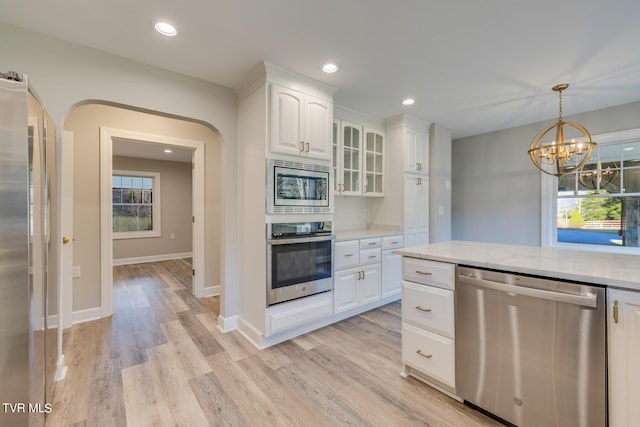 kitchen featuring white cabinetry, light wood-type flooring, stainless steel appliances, and a healthy amount of sunlight