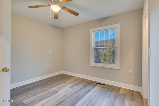 empty room with ceiling fan and light wood-type flooring