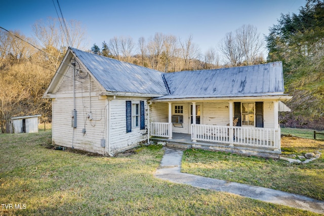 view of front facade featuring a porch, a front lawn, and an outdoor structure