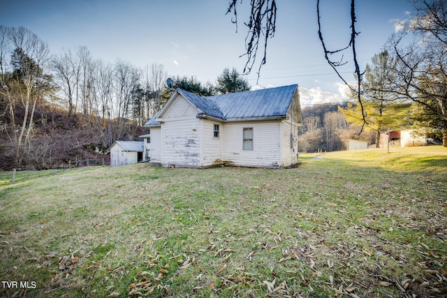 rear view of property featuring an outdoor structure and a lawn