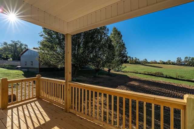 wooden terrace with a lawn and a rural view