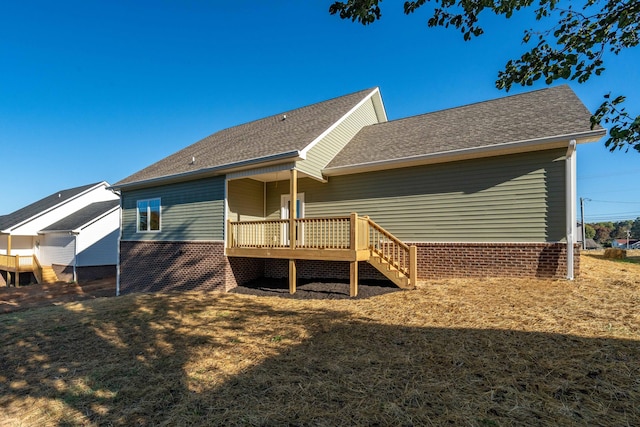 rear view of house featuring a deck and a yard