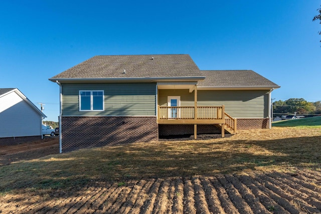 back of house with a deck and a yard