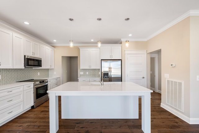 kitchen featuring tasteful backsplash, hanging light fixtures, stainless steel appliances, and a kitchen island with sink