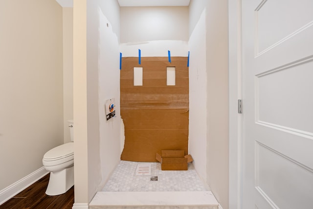 bathroom featuring toilet, hardwood / wood-style flooring, and walk in shower