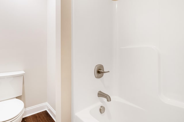 bathroom featuring toilet, shower / bath combination, and hardwood / wood-style floors