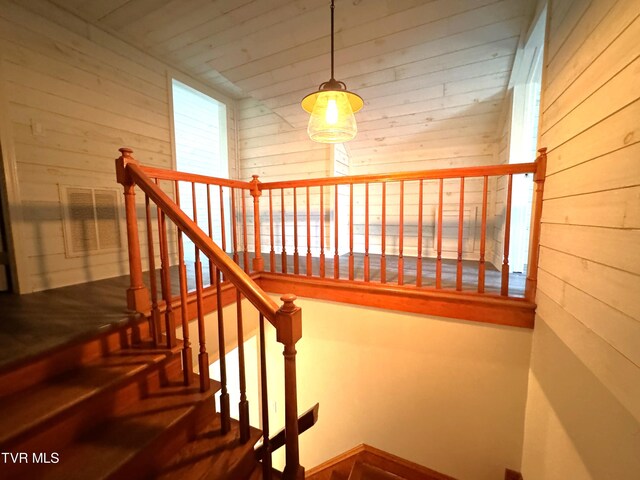 stairway featuring wood walls