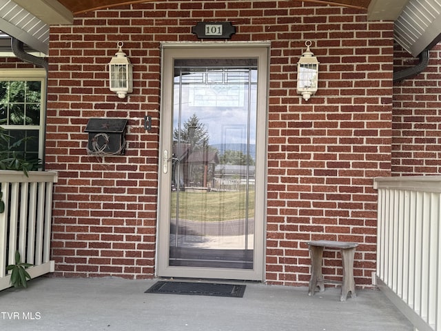 view of exterior entry featuring brick siding