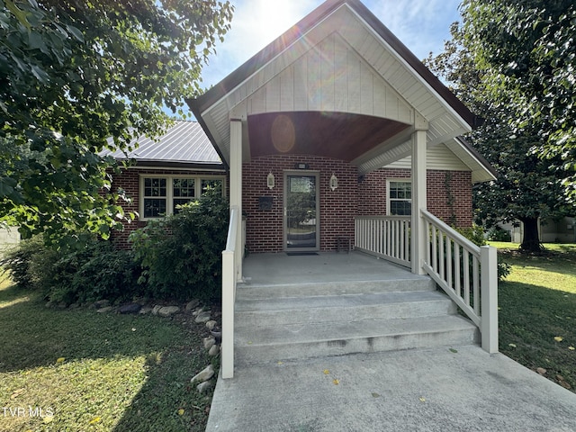 property entrance featuring a yard and brick siding