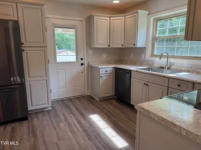 kitchen with stainless steel fridge, dark wood-type flooring, sink, dishwasher, and white cabinetry