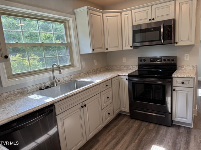 kitchen featuring dark hardwood / wood-style flooring, sink, white cabinets, and appliances with stainless steel finishes