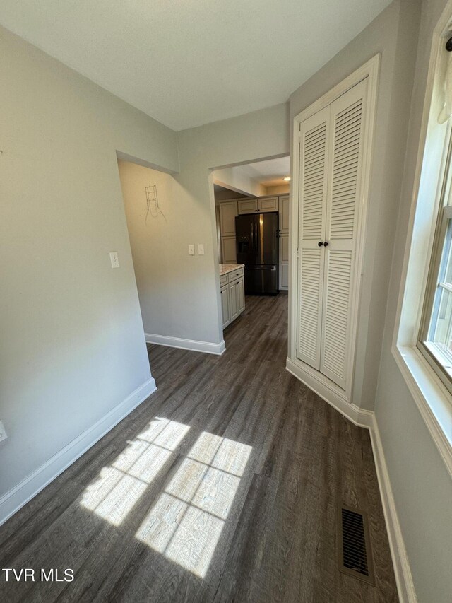 unfurnished room with dark hardwood / wood-style flooring