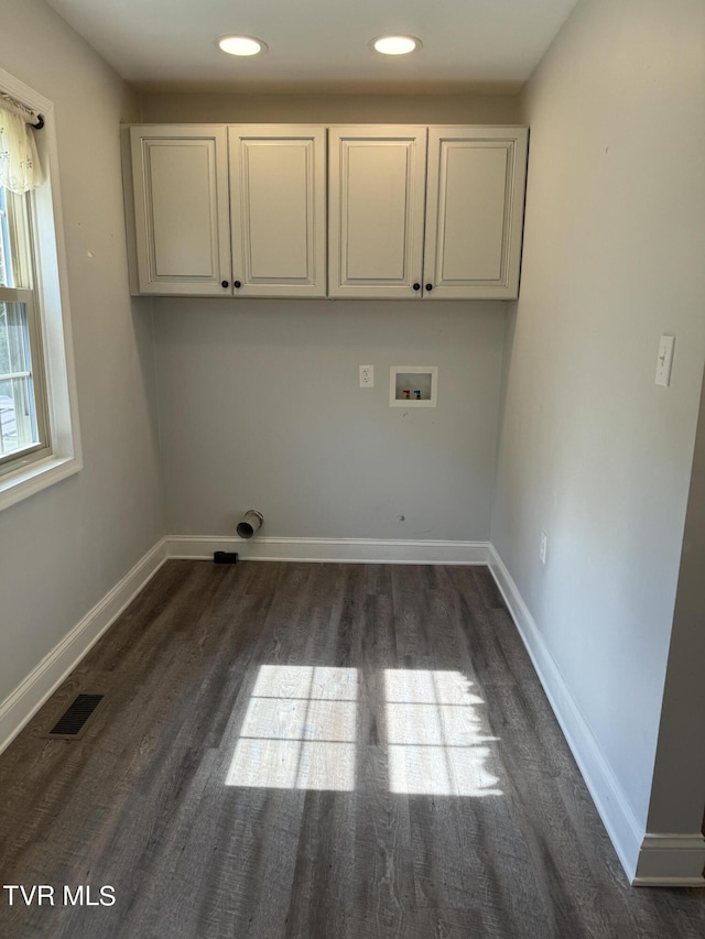 clothes washing area featuring hookup for a washing machine, dark wood-style floors, visible vents, baseboards, and cabinet space