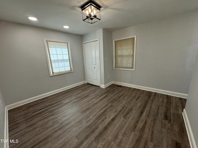 unfurnished bedroom featuring dark wood-type flooring, recessed lighting, baseboards, and a closet