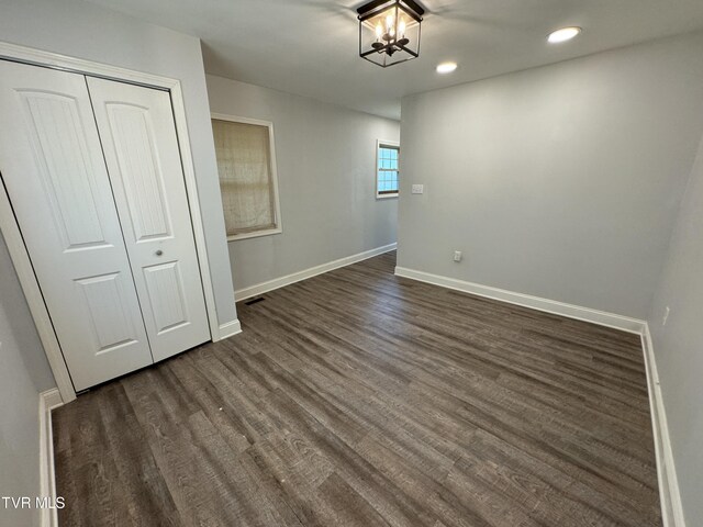 interior space with a chandelier, dark hardwood / wood-style flooring, and a closet