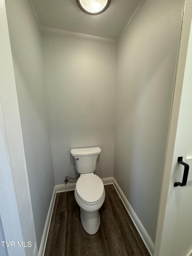 bathroom with toilet, wood finished floors, and baseboards