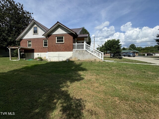 view of side of home with a yard