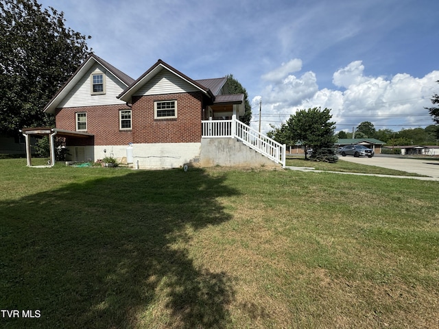 view of side of property featuring a yard, brick siding, and metal roof