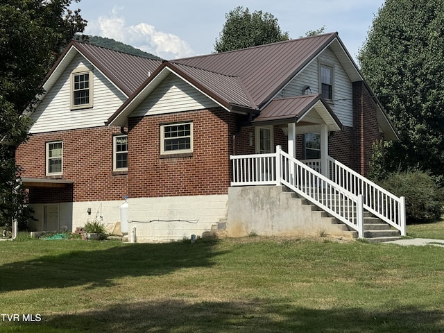 view of front of home featuring brick siding, a standing seam roof, metal roof, and a front yard