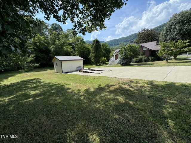 view of yard with a mountain view and an outdoor structure