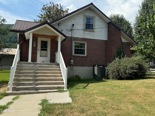 view of front of property with a front lawn and central air condition unit