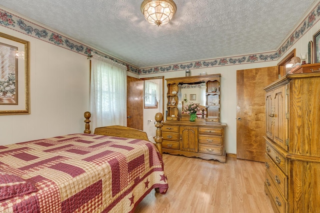 bedroom with a textured ceiling and light wood-type flooring