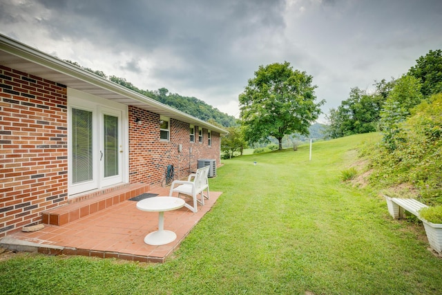 view of yard featuring central air condition unit, a patio area, and french doors