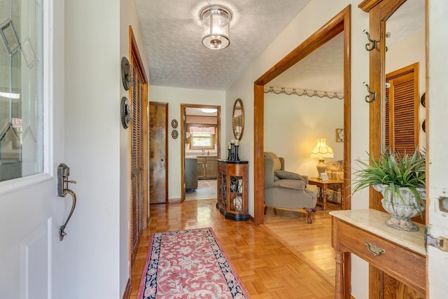 entrance foyer with light parquet floors and a textured ceiling