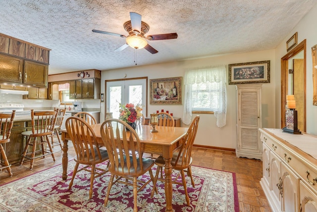 dining space featuring a textured ceiling, light parquet flooring, a wealth of natural light, and ceiling fan