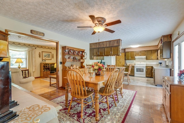 dining area featuring ceiling fan and a textured ceiling