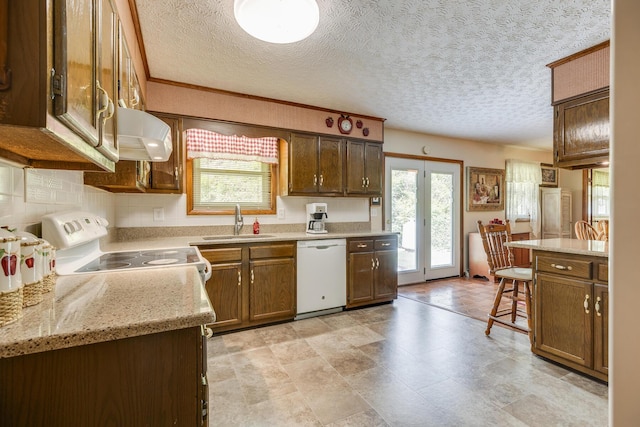 kitchen featuring a kitchen breakfast bar, a textured ceiling, sink, dishwasher, and range