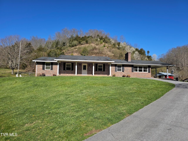 single story home with a front yard and a carport