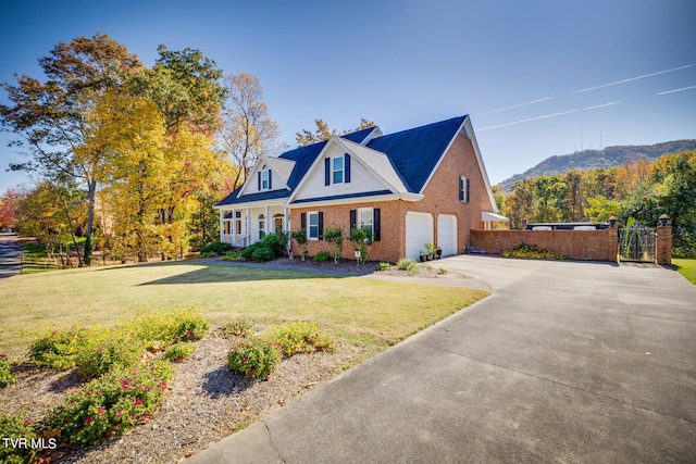 cape cod-style house with a front yard, a mountain view, and a garage